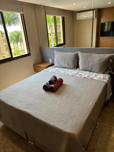 a large bed with two pairs of shoes on it at Flat no Life Resort a Beira Lago in Brasilia