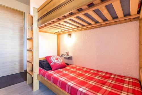 - une chambre avec des lits superposés et un oreiller rouge dans l'établissement Résidence Boedette A - Appartement rénové · Départ et retour skis aux pieds · Balcon vue montagnes MAE-1114, aux Menuires
