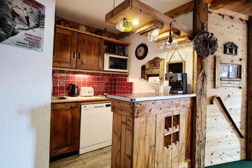 - une cuisine avec des placards en bois et des appareils blancs dans l'établissement Résidence Necou - Appartement agréable et lumineux · Proche des pistes · Balcon MAE-1154, aux Menuires