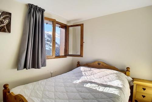 ein Schlafzimmer mit einem Bett und einem Fenster in der Unterkunft Résidence Les Cristaux - Appartement de standing rénové · Proche des pistes · Balcon · Sauna · Hammam · WIFI MAE-1164 in Levassaix
