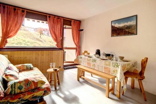 un salon avec une table et un canapé dans l'établissement Résidence Asters C6 - Studio lumineux · Accès direct aux pistes · Balcon vue sur pistes MAE-1184, aux Menuires