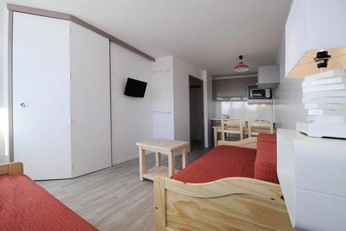 une petite pièce avec un lit et une table dans l'établissement Résidence Boedette D - Appartement rénové · Départ et retour skis aux pieds · Balcon MAE-1214, aux Menuires