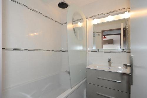 une salle de bain blanche avec un lavabo et une douche dans l'établissement Résidence Boedette D - Appartement rénové · Départ et retour skis aux pieds · Balcon MAE-1214, aux Menuires