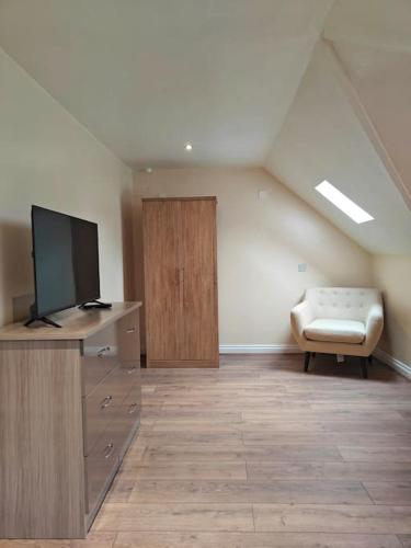 a living room with a tv and a chair at Stunning 5-bed House near NEC & BHX in Solihull