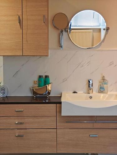 a bathroom with a sink and a mirror at Stunning 5-bed House near NEC & BHX in Solihull
