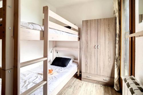 une chambre avec un lit superposé avec une échelle dans l'établissement Résidence Astragales - Appartement confortable · Proche des pistes · Balcon · Casier à skis MAE-1324, aux Menuires