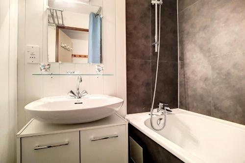 une salle de bain avec un lavabo et une baignoire dans l'établissement Résidence Astragales - Appartement confortable · Proche des pistes · Balcon · Casier à skis MAE-1324, aux Menuires