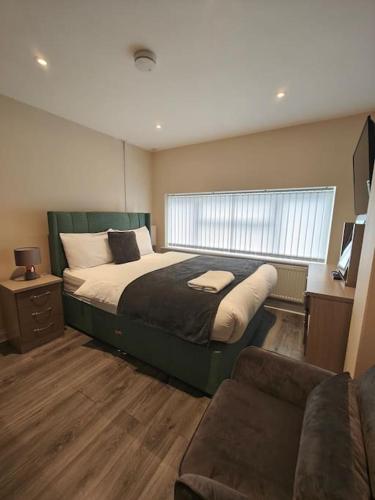 a bedroom with a large bed and a couch at Luxury 5-bed House near NEC & BHX in Solihull