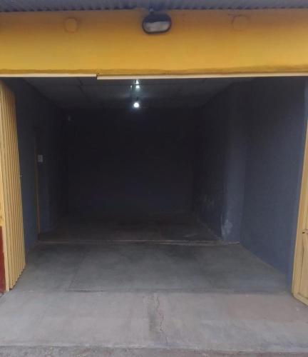 Una habitación oscura con una pared amarilla en un garaje. en Casa Wasi Qellu, en San Rafael