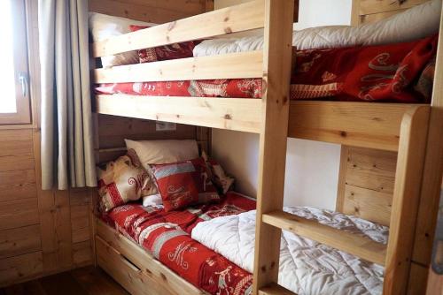 un lit superposé dans une cabane en rondins avec un lit dedans dans l'établissement Résidence Les Charmettes - Appartement rénové · Cœur de station · Balcon MAE-1454, aux Menuires