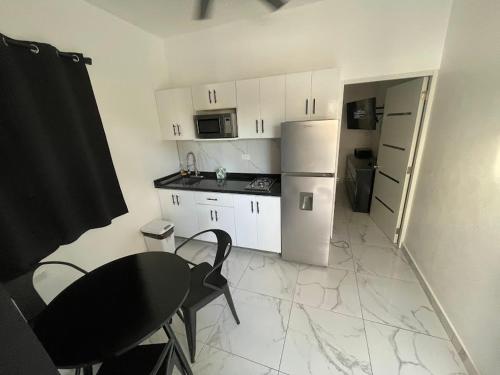 a small kitchen with a table and a refrigerator at LEVEL suites #8 in Sosúa