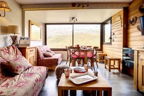 un salon avec un canapé et une table dans l'établissement Résidence Biellaz - Appartement rénové, lumineux et chaleureux · Départ et retour skis aux pieds · Vue montagne MAE-1474, aux Menuires