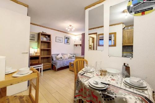 une cuisine et un salon avec une table et une salle à manger dans l'établissement Résidence Balcons D'olympie - Appartement confortable avec cabine · Proche des pistes · Balcon MAE-1514, aux Menuires