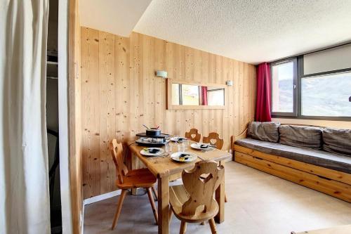Cette petite chambre comprend une table et un canapé. dans l'établissement Résidence Median - Appartement rénové · Proche des pistes · Balcon MAE-1534, aux Menuires