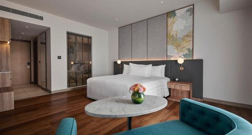 a hotel room with a bed and a table and chairs at PARKROYAL Langkawi Resort in Pantai Cenang