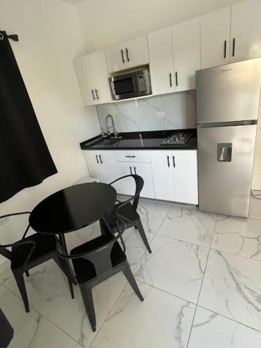 a kitchen with a black table and a black chair at LEVEL suites #8 in Sosúa