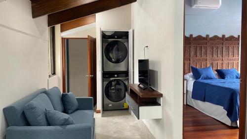 a living room with a blue couch and a bed at Apartamento Gratitud in Alajuela City