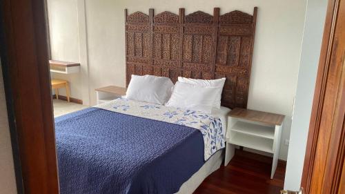 a bedroom with a bed with a blue comforter at Apartamento Gratitud in Alajuela City