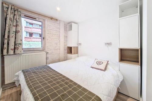une petite chambre avec un lit et une fenêtre dans l'établissement Résidence Alpages De Reberty - Appartement rénové et lumineux· Proche des pistes · Balcon · Piscine MAE-1674, aux Menuires
