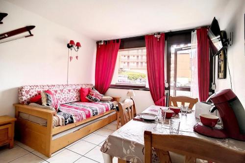 - un salon avec un canapé et une table à manger dans l'établissement Résidence Asters B3 - Studio cabine agréable · Proche des pistes · Balcon MAE-1724, aux Menuires