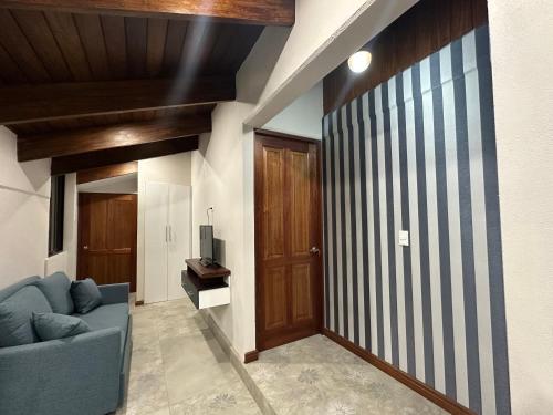 a living room with a blue couch and a wooden door at Apartamento Gratitud in Alajuela City