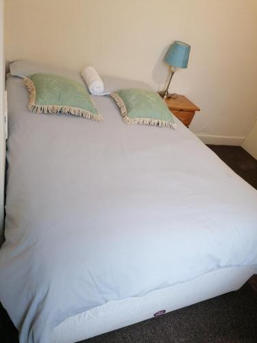 a large white bed with two pillows on it at Hygis Home Of Relaxations in Stoke on Trent