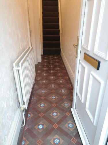 a hallway with a door and a tiled floor at Hygis Home Of Relaxations in Stoke on Trent