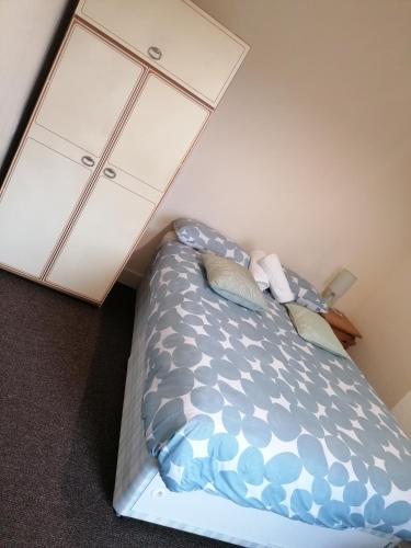 a bedroom with a bed and a white cabinet at Hygis Home Of Relaxations in Stoke on Trent