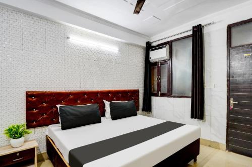 a bedroom with a large bed with a red headboard at Super Hotel O The Maruti hotel in Noida