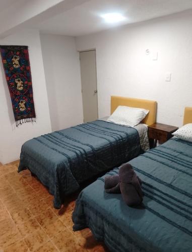 a bedroom with two beds and a teddy bear on the couch at Casa Nance Alojamientos XAMAN HÁ Centro Mercado 28 y ADO Suite Familiar 3 Personas in Cancún