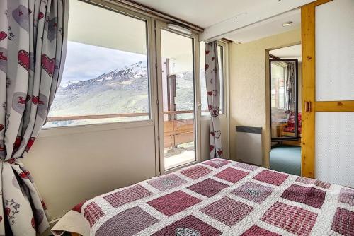 une chambre avec un lit et une grande fenêtre dans l'établissement Résidence Burons - Appartement spacieux · Ski aux pieds · Balcon MAE-2154, aux Menuires