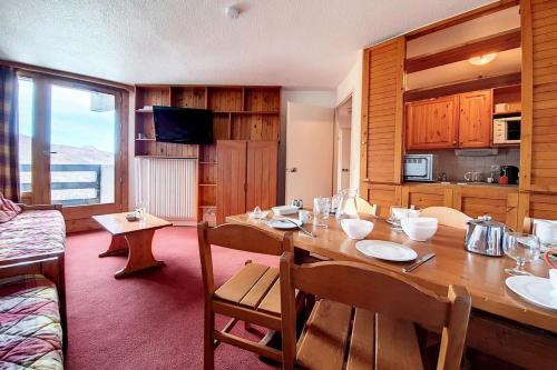 une salle à manger avec une table en bois et une cuisine dans l'établissement Résidence Chaviere - Appartement confortable · Au pied des pistes · Balcon MAE-2254, aux Menuires