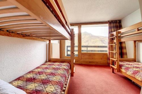 une chambre avec deux lits superposés et une fenêtre dans l'établissement Résidence Chaviere - Appartement confortable · Au pied des pistes · Balcon MAE-2254, aux Menuires