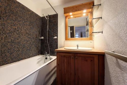 une salle de bain avec un lavabo, une baignoire et un miroir dans l'établissement Résidence Chaviere - Appartement confortable · Au pied des pistes · Balcon MAE-2254, aux Menuires