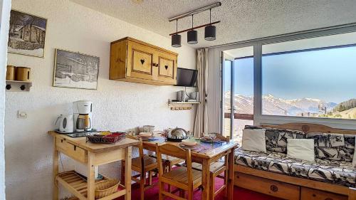 Cette petite chambre comprend une table et un canapé. dans l'établissement Résidence Boedette A - Appartement duplex · Départ et retour skis aux pieds · Balcon vue montagne MAE-2244, aux Menuires