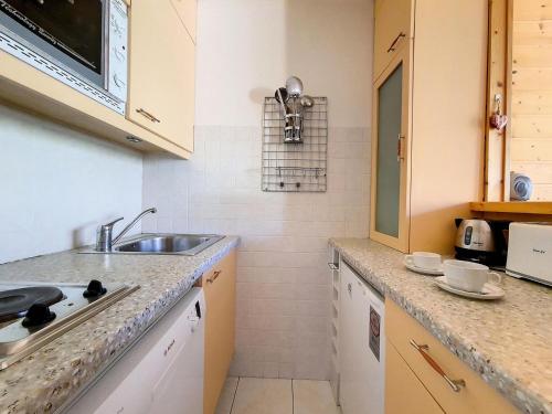 une cuisine avec un évier et un plan de travail dans l'établissement Résidence Coryles A - Appartement spacieux · A deux pas des pistes · Balcon MAE-2174, aux Menuires