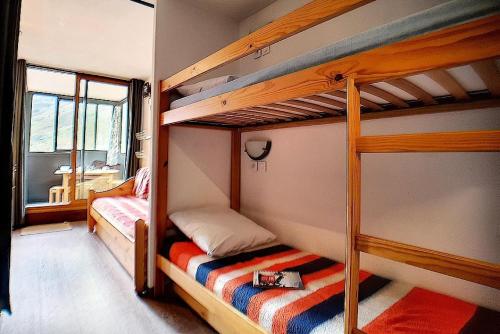 une chambre avec deux lits superposés et une fenêtre dans l'établissement Résidence Ski Soleil - Appartement fonctionnel · Départ ski aux pieds · Balcon loggia ouest MAE-2344, aux Menuires