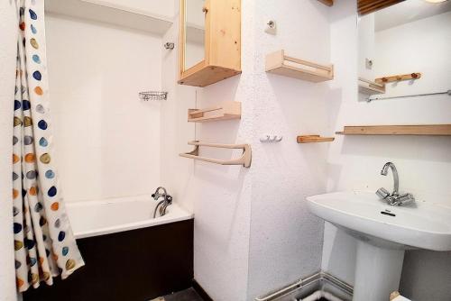 La petite salle de bains est pourvue d'un lavabo et d'une baignoire. dans l'établissement Résidence Ski Soleil - Appartement fonctionnel · Départ ski aux pieds · Balcon loggia ouest MAE-2344, aux Menuires
