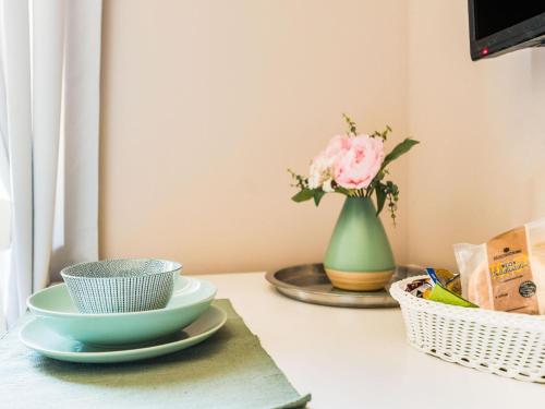 a table with two bowls and a vase with a flower at Apartment in Bad Camberg near Taunus Mountains in Bad Camberg