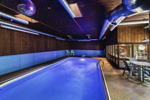 a swimming pool in a room with a table at Skyline Villa Indoor Pool Hot Tub in Millard