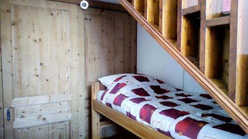 Ce lit superposé se trouve dans un dortoir doté d'un escalier en bois. dans l'établissement Résidence Evons - Studio rénové · Au pied des pistes · Balcon · Wifi MAE-2464, aux Menuires