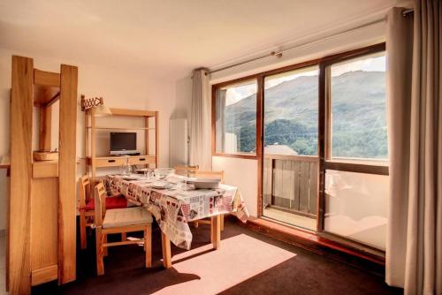 une salle à manger avec une table et une grande fenêtre dans l'établissement Résidence Sarvan - Appartement lumineux · Départ et retour skis aux pieds · Balcon MAE-2494, aux Menuires