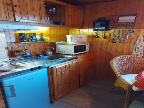 a kitchen with a sink and a microwave at Chalet with Garden in Lotharingen in Saint-Maurice-sur-Moselle