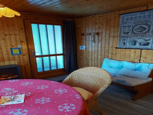 a room with a table and a chair and a window at Chalet in Vosges near Rouge Gazon Ski Resort in Saint-Maurice-sur-Moselle