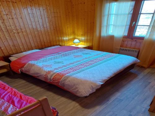 a bedroom with a bed in a wooden room at Chalet in Vosges near Rouge Gazon Ski Resort in Saint-Maurice-sur-Moselle