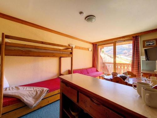 une chambre avec deux lits superposés et une table dans l'établissement Résidence Valmonts A - Appartement standard · Départ ski aux pieds · Balcon MAE-2624, aux Bruyères