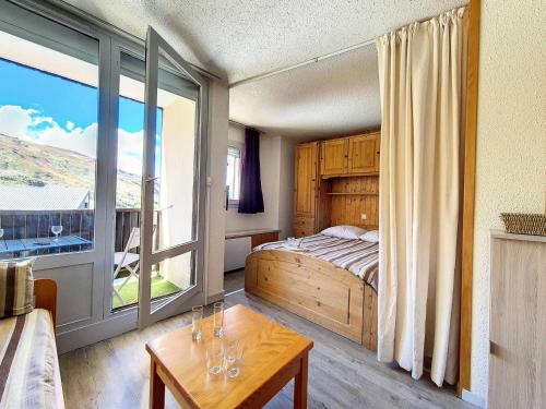 une chambre avec un lit et une grande fenêtre dans l'établissement Résidence Villaret - Studio atypique avec beaucoup de rangement MAE-2694, aux Menuires