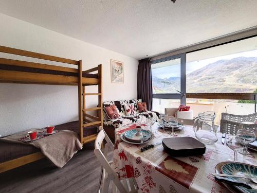 Cette chambre dispose d'une table à manger et de lits superposés. dans l'établissement Résidence Tougnette - Studio rénové lumineux · Départ et retour skis aux pieds · Balcon MAE-2724, aux Menuires