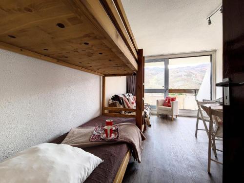 une chambre avec un lit dans une chambre avec une fenêtre dans l'établissement Résidence Tougnette - Studio rénové lumineux · Départ et retour skis aux pieds · Balcon MAE-2724, aux Menuires