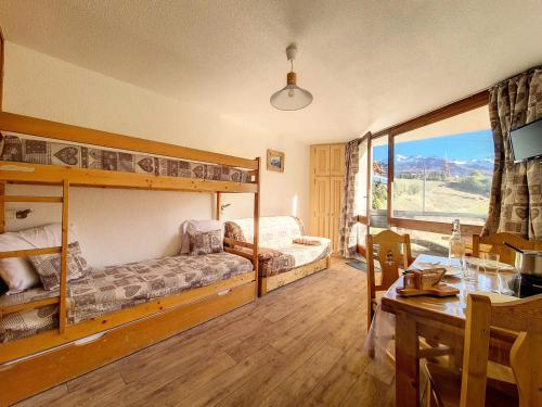 - une chambre avec 2 lits superposés et une salle à manger avec une table dans l'établissement Résidence Caron - Studio lumineux · Départ et retour skis aux pieds · Balcon MAE-2734, aux Menuires